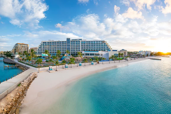 Luxury beachfront resort exterior capturing coastal architecture, shoreline, and guest arrival experience.