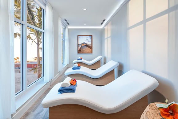 Spa interior featuring relaxation loungers, natural light, and calming design for wellness environments.